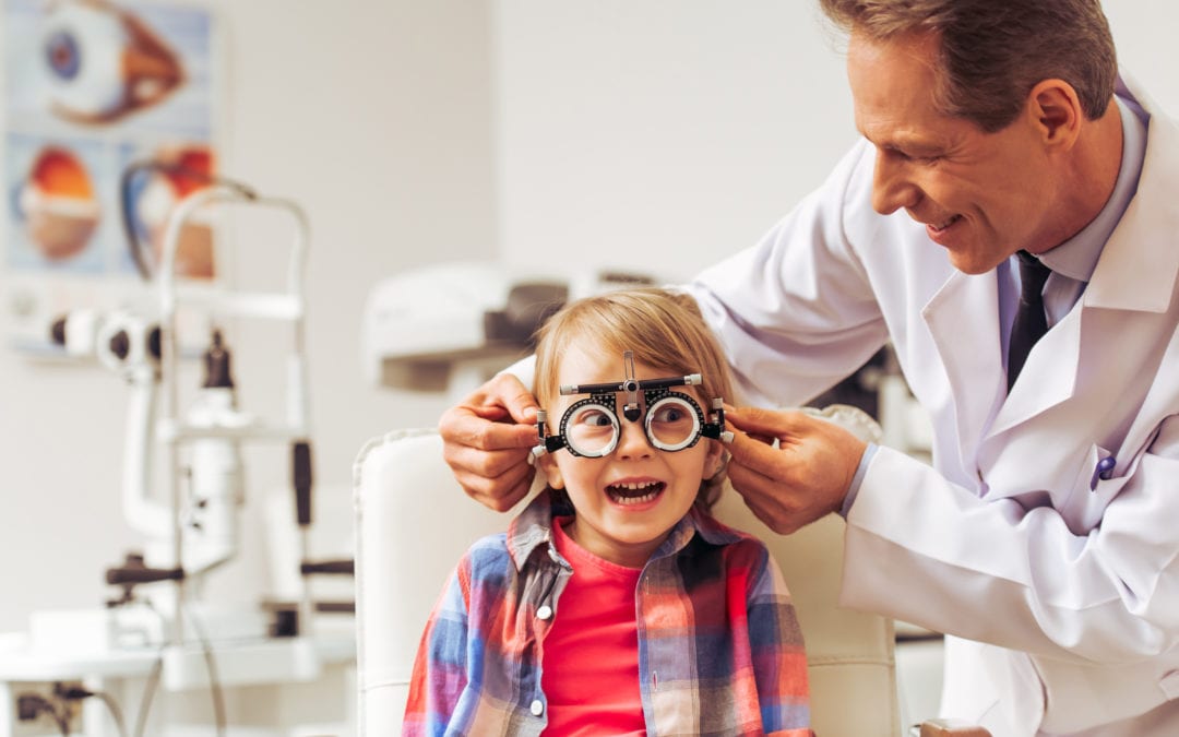 Little boy gets fitted with glasses at optometrist's.