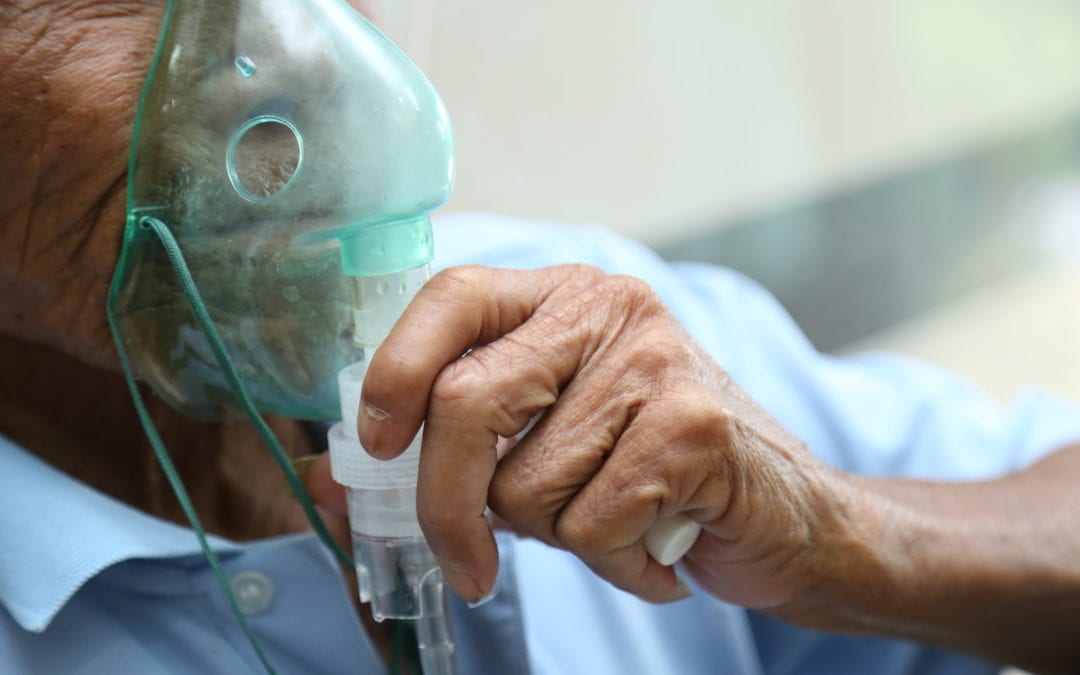Man holding oxygen mask to face.