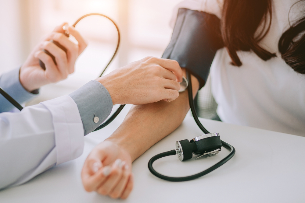 Doctor checking patient's high blood pressure